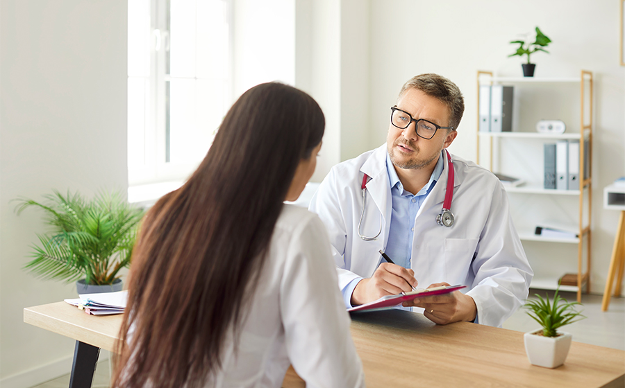 Lekarz siedzi przy biurku i odpowiada na pytania pacjentki dotyczące przeszczepu narządu w Polsce